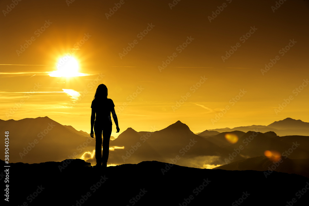 Frau betrachtet einen Sonneaufgang im Gebirge