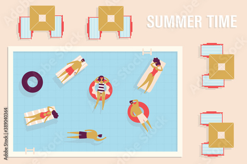 Group of vacationers swims in pool on inflatable rings or rafts. Parasols and sun loungers around pool. Concept of resting in hotel and vacation
