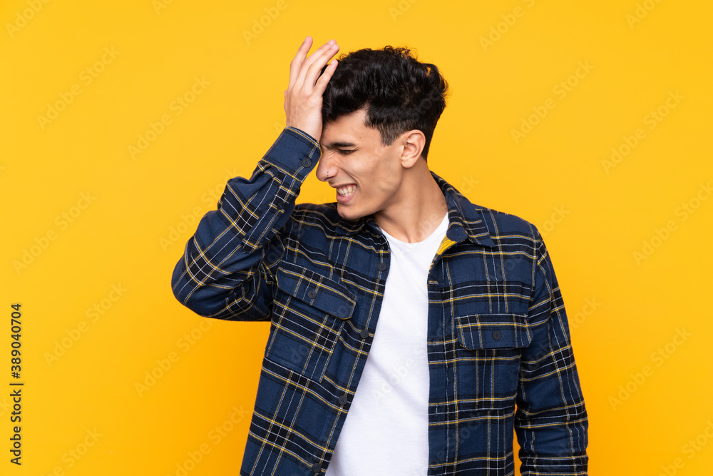Young Argentinian man over isolated yellow background having doubts with confuse face expression