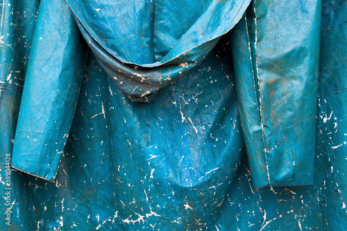 Canvas Print Backside of old, tattered blue raincoat