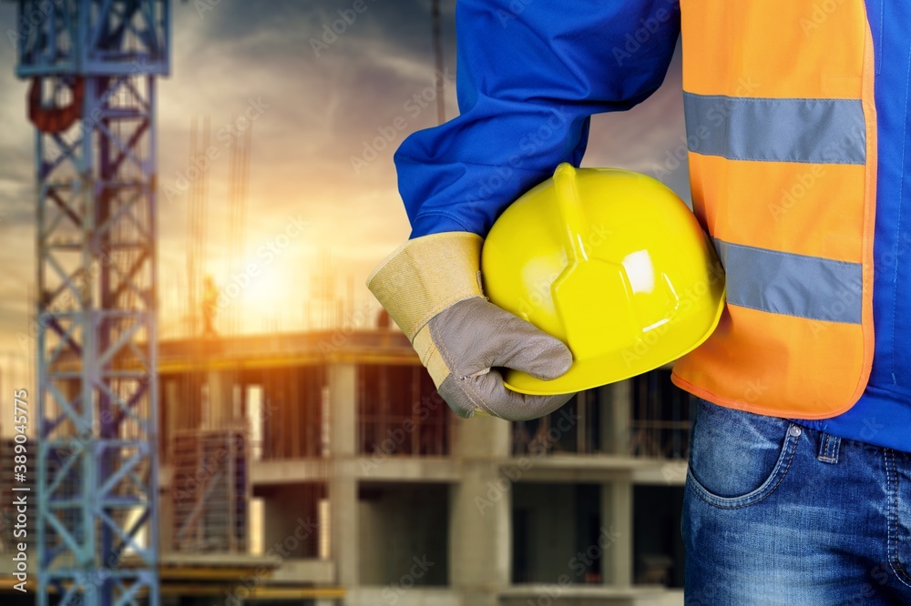 Worker man with helmet in hands on background Worker man with helmet in hands on background