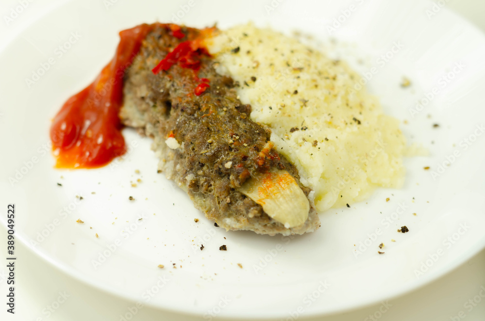 Roasted minced meat formed in the shape of a finger, topped with a tomato and pepper sauce, a creative way of serving food for Halloween