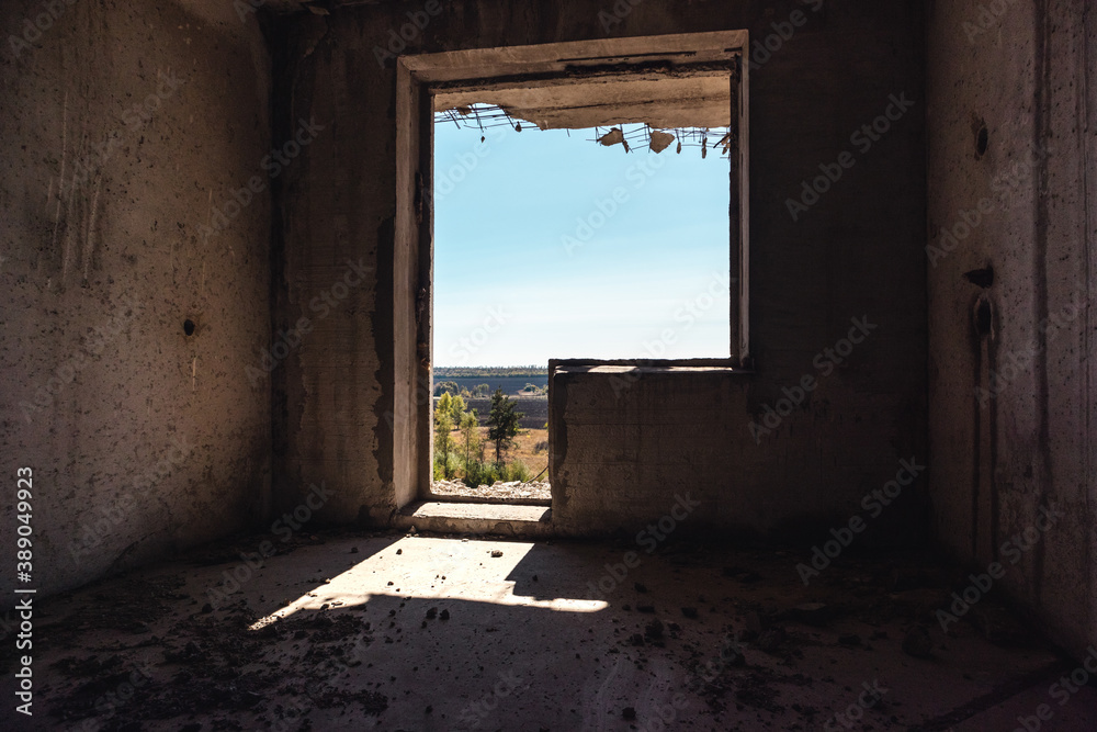 Window from weathered abandoned room to sunny day