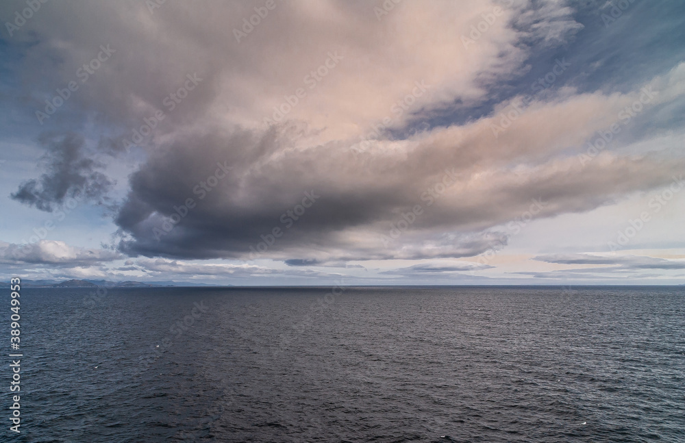 Cape Horn, Wollaston Islands, Chile - December 14, 2008: Brown cloudscape with blue patches above east side of archipelago thus Atlantic Ocean dark water. Cape Horn, Wollaston Islands, Chile - December 14, 2008: Brown cloudscape with blue patches above east side of archipelago thus Atlantic Ocean dark water.