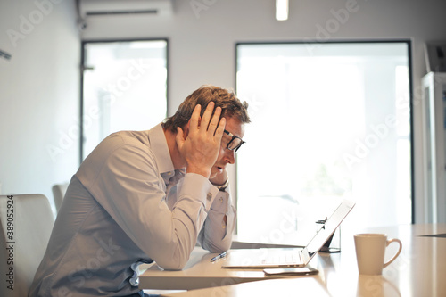 worried man in front of a computer in a modern office
