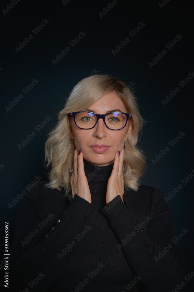 Beautiful young blonde woman with blue eyes isolated on back wearing a black top Beautiful young blonde woman with blue eyes isolated on back wearing a black top