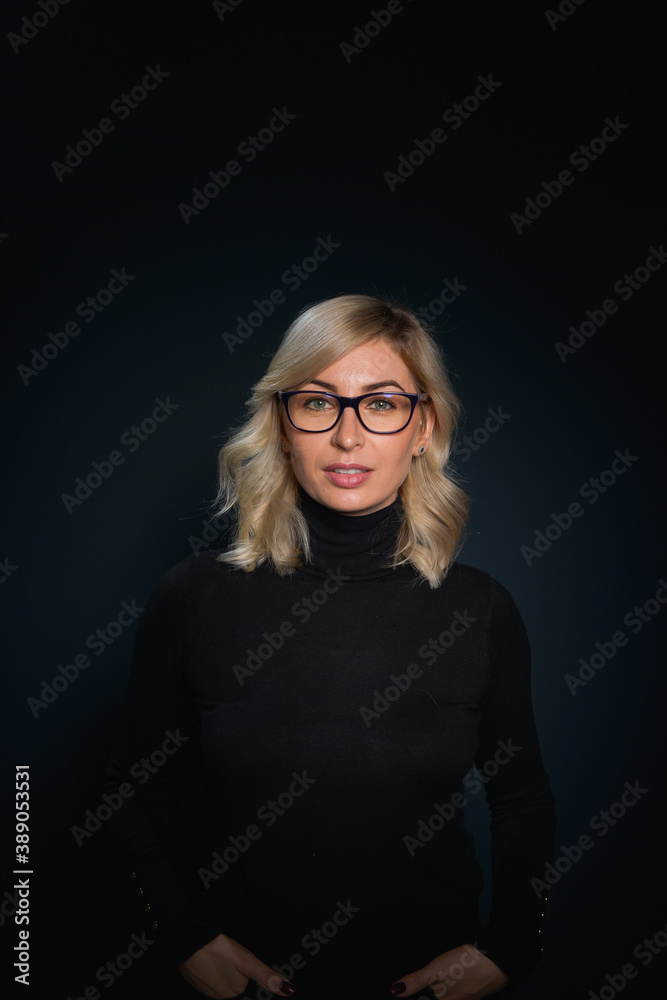 Beautiful young blonde woman with blue eyes isolated on back wearing a black top Beautiful young blonde woman with blue eyes isolated on back wearing a black top
