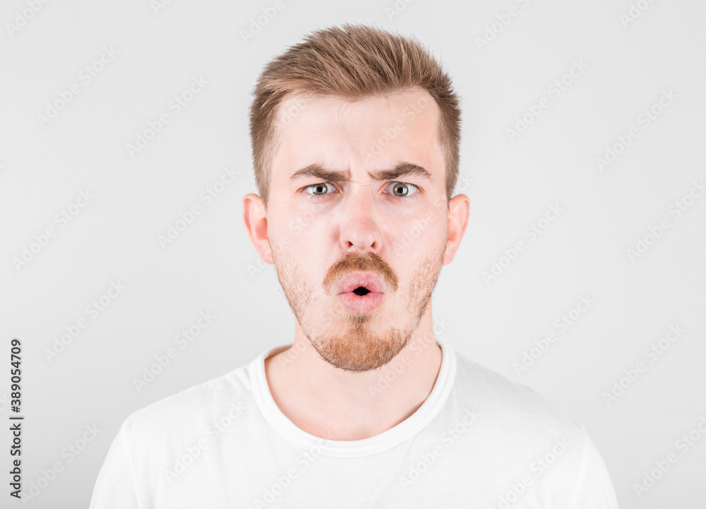 Surprised young guy is posing in studio on white background Surprised young guy is posing in studio on white background