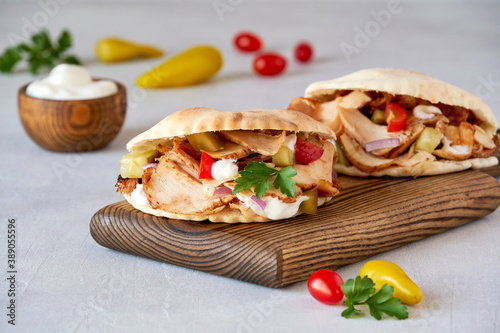 Foto Shawarma with chicken  and garlic sauce in pita bread on wooden board