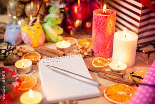 Notebook  pen and various Christmas decoration and items on the wooden table. Winter holidays  festive atmosphere.
