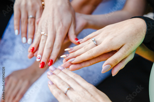 the bride shows her bridesmaids the wedding ring on her finger