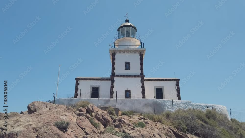 Lighthouse on little mountain in Santorini island with Aegean Sea in the Cyclades, Greece