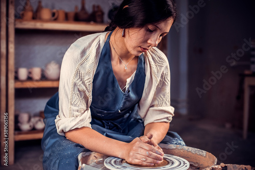 Charming craftsman at his wheel creating a new masterpiece. Concept of ceramic art.