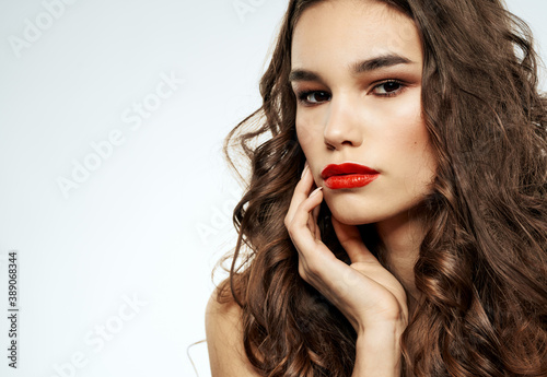 Model with bright makeup woman touches face with hand cropped view