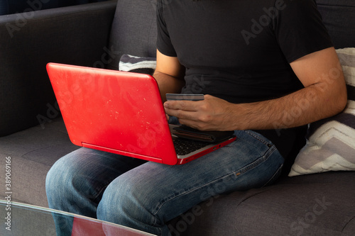 top view and close up of a man shopping online on a laptop and holding a credit card
