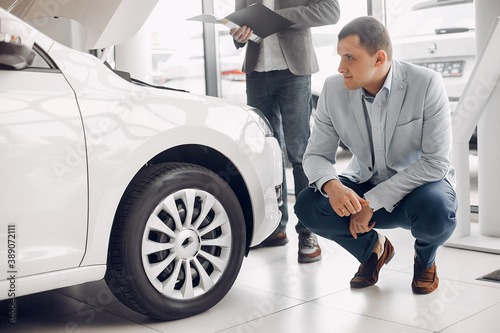 Man buying the car. Businessman in a car salon. Assistant with a client © prostooleh