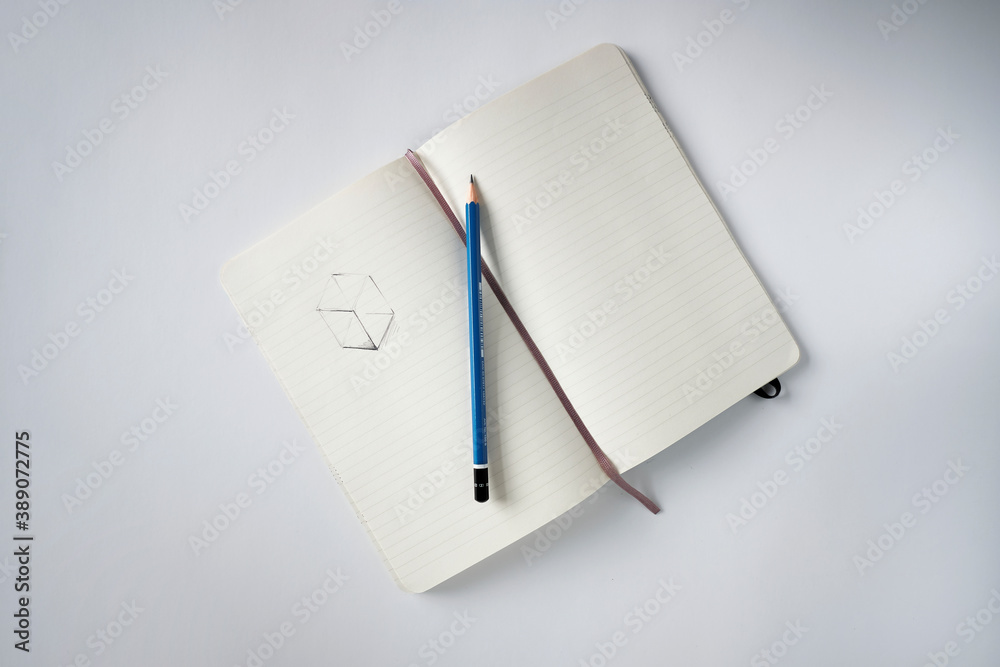 Top view notebook with a sketch and pencil on a white desk Top view notebook with a sketch and pencil on a white desk