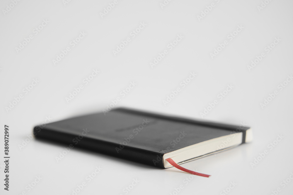 Closed notebook on a white desk Closed notebook on a white desk