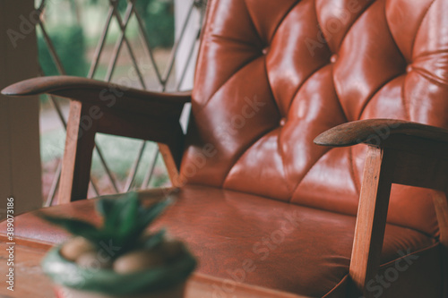 Foto The wooden armrests of the old brown sofa with backrest sit comfortably in the living room