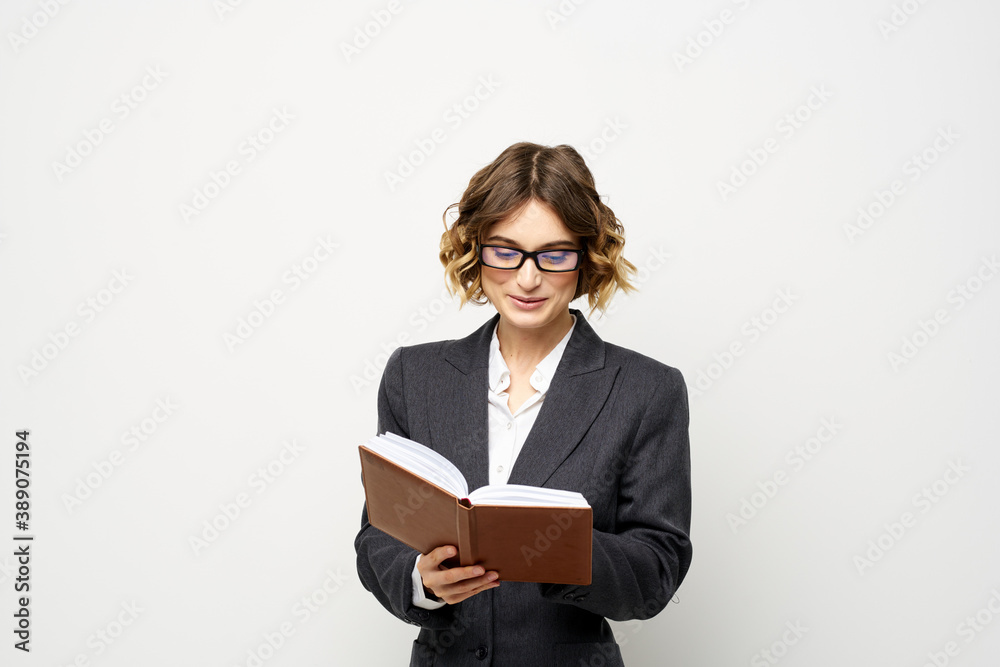 Business woman with notepad and glasses work light background cropped view of suit model. Business woman with notepad and glasses work light background cropped view of suit model.