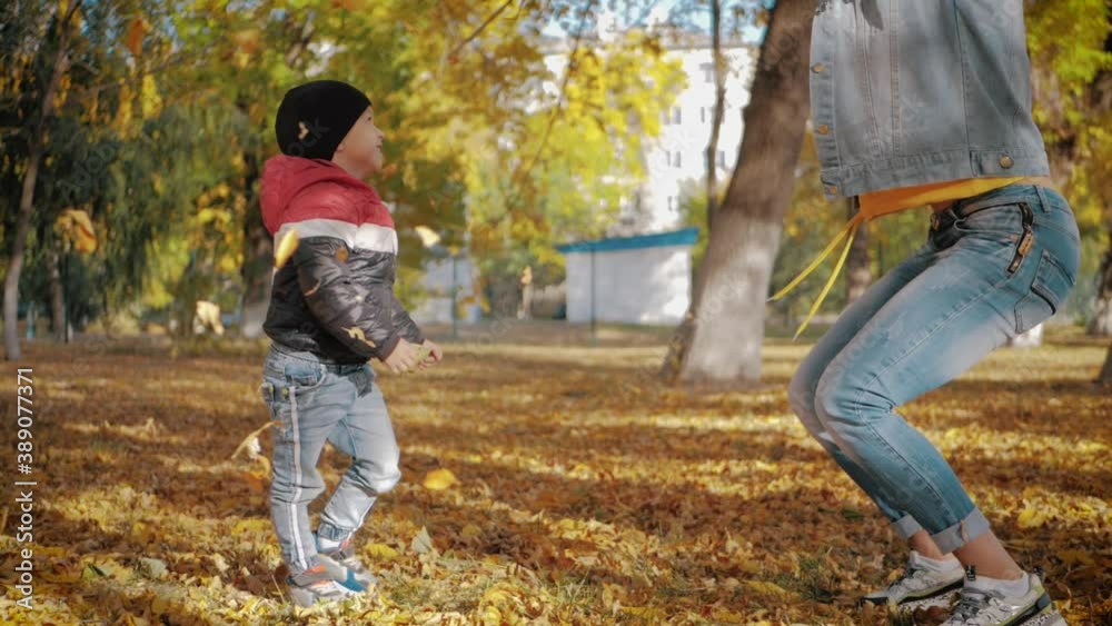Mom playing with son in autumn park. Happy moments together. Family in the autumn park. Mom playing with son in autumn park. Happy moments together. Family in the autumn park.