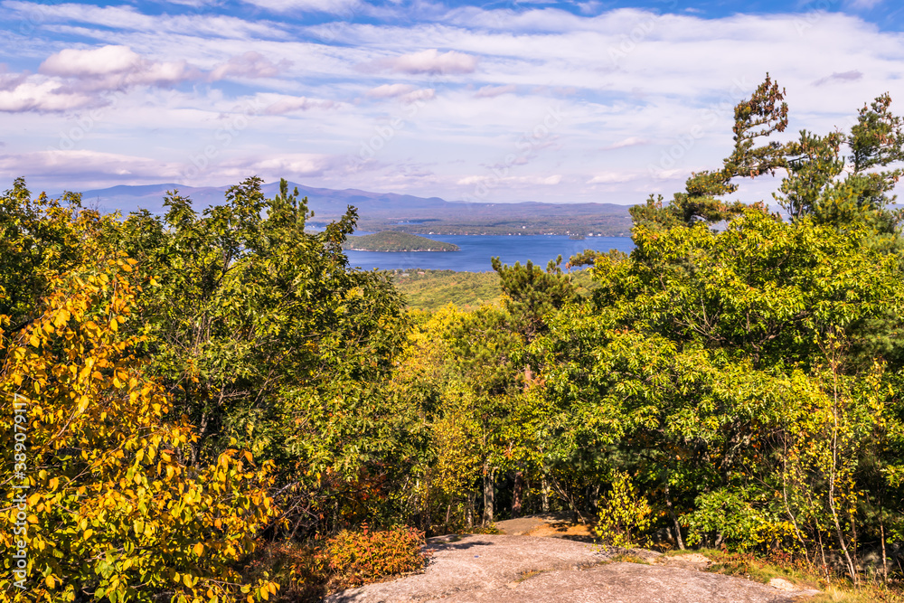 Lake Winnipesaukee seen through the trees near the top of Mount Major in New Hampshire
