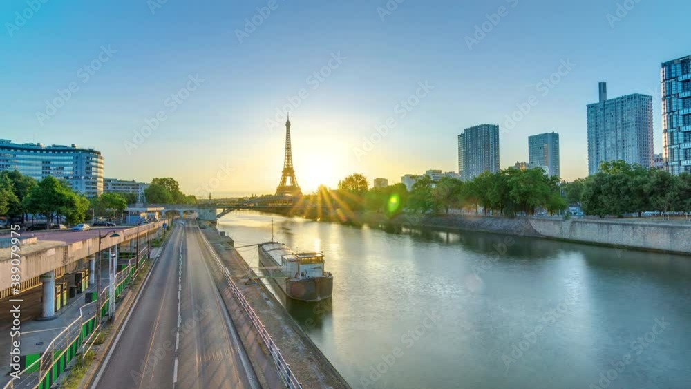 Eiffel Tower sunrise timelapse with boats on Seine river and in Paris, France. View from Grenelle bridge. Modern buildings and traffic on a road Eiffel Tower sunrise timelapse with boats on Seine river and in Paris, France. View from Grenelle bridge. Modern buildings and traffic on a road