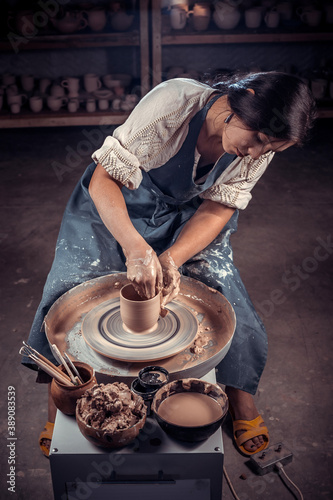 Stylish craftsmen at his wheel creating a new masterpiece. Making pottery. photo