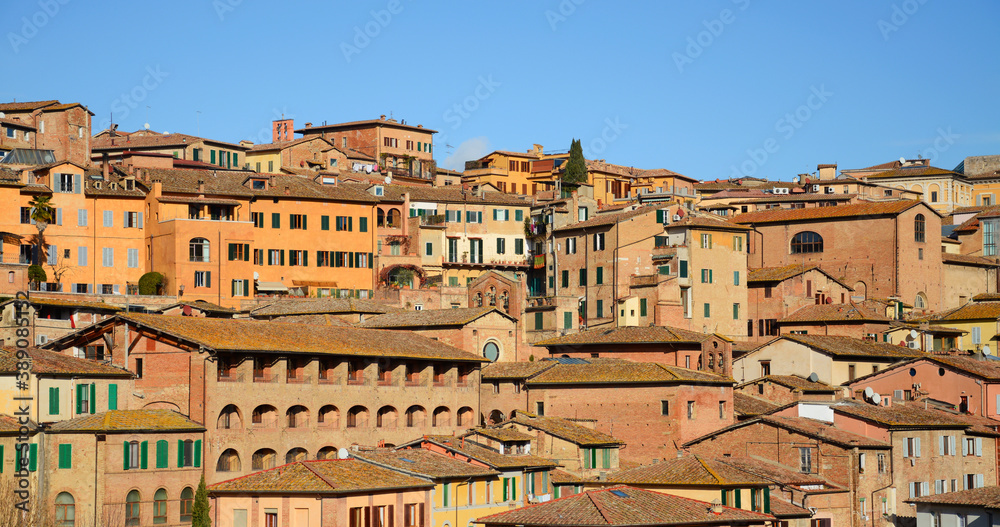 City of Siena in Tuscany, Italy. Brick facades in winter sunlight. Clear blue sky.  Typical architecture in Siena.