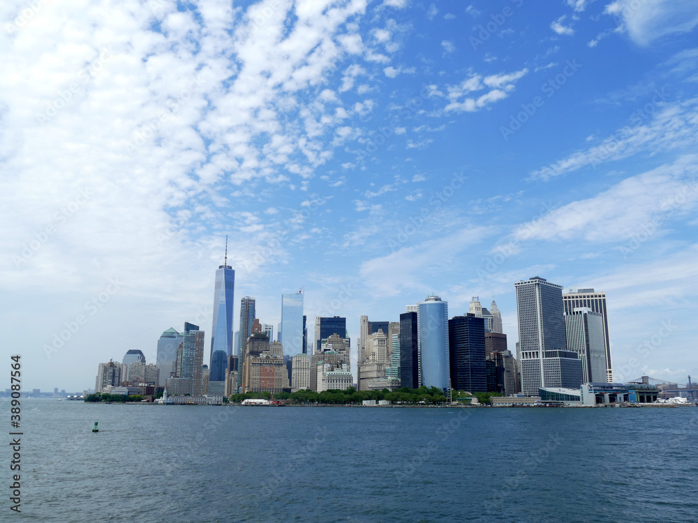 View of Manhattan skyline from the sea with cloudy blue sky