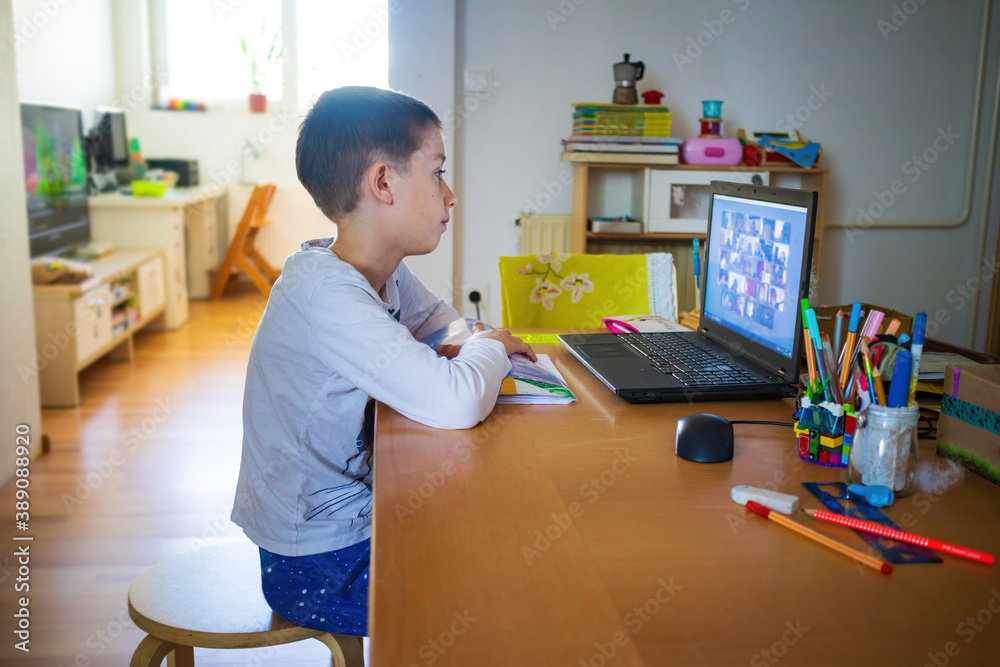 Child at home having remote school on laptop computer. - obrazy, fototapety, plakaty 