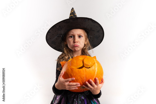 little girl in halloween costume holding a pumpkin in her hands on a white background