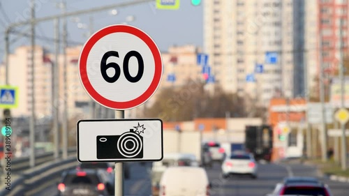 60km/h speed limit sign with radar control with car traffic on a city highway