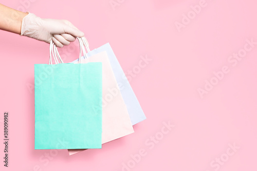 Gloved hands hold paper bags. Business, delivery, shopping during quarantine. Safe contact concept.