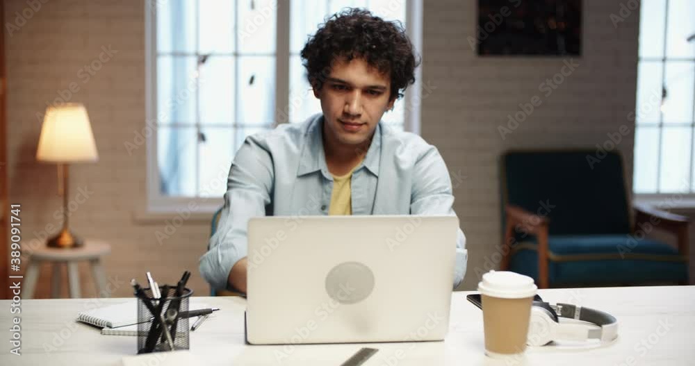Young asian freelancer starting his work. Focused remote worker opening up his laptop and working on his project during self isolation 4k footage