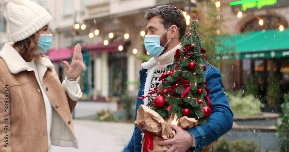 Close up portrait of Caucasian male and female lovely couple in masks having fun and fooling around on street in decorated city. Happy friends with outdoor on Christmas eve. Holidays spirit concept Close up portrait of Caucasian male and female lovely couple in masks having fun and fooling around on street in decorated city. Happy friends with outdoor on Christmas eve. Holidays spirit concept