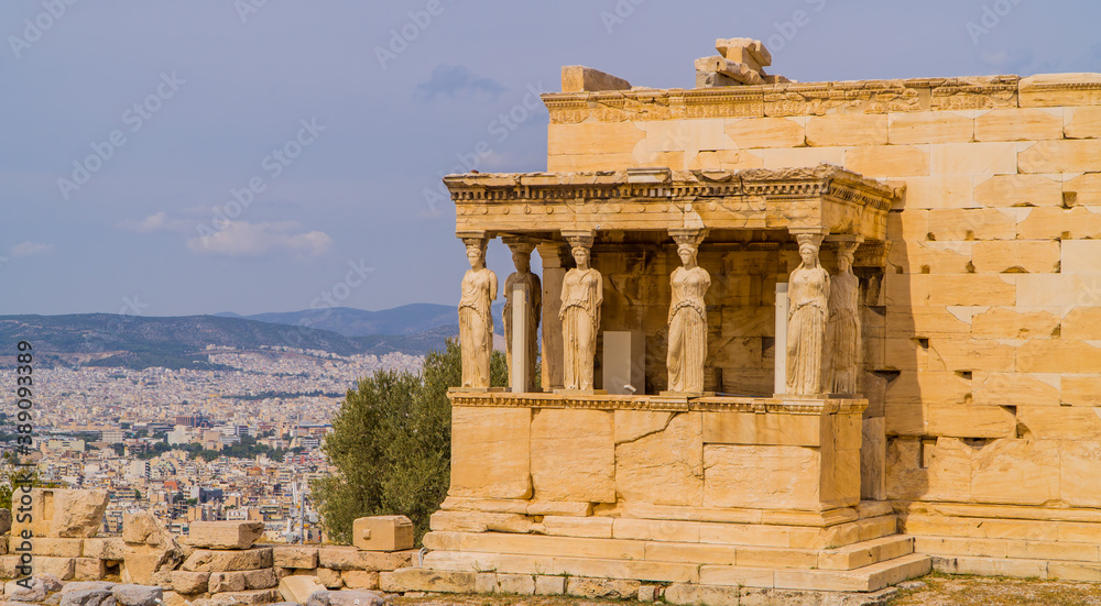 The Caryatides, Erechtheion Temple at Athens Acropolis with a city view of Athens, Greece in the background
