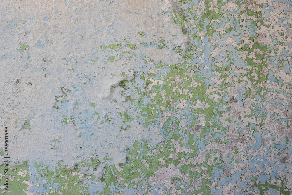 Peeling paint on the wall. Old concrete wall with cracked flaking paint. Weathered rough painted surface with patterns of cracks and peeling. High resolution texture for background and design. Closeup