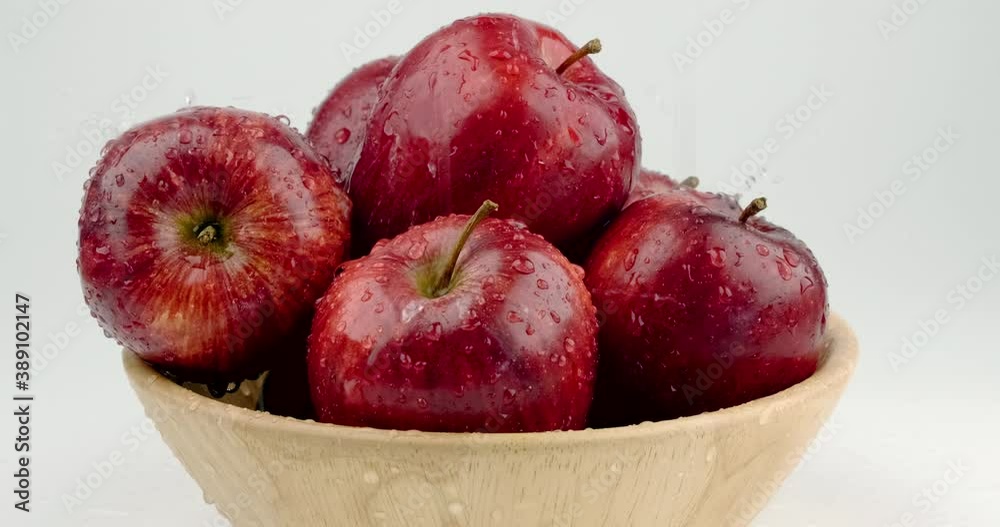 Truck shot close up of red apple group pile in wooden 
 bowl with water dropping on skin surface