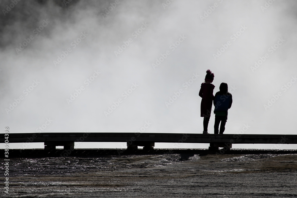Yellowstone brother and sister children silhouette boardwalk 4K. Geyser Yellowstone Wyoming, Montana and Idaho, USA. Geothermal geological environment ecosystem landscape. Biology geography ecology. Yellowstone brother and sister children silhouette boardwalk 4K. Geyser Yellowstone Wyoming, Montana and Idaho, USA. Geothermal geological environment ecosystem landscape. Biology geography ecology.