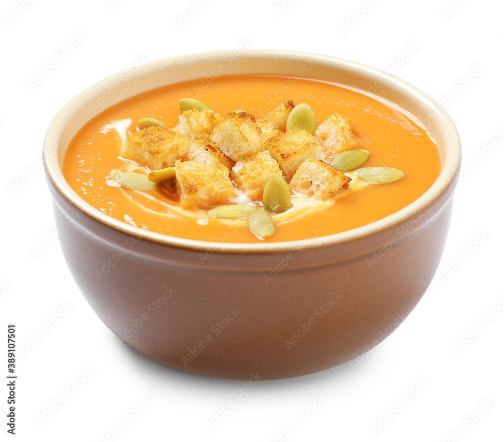 Tasty creamy pumpkin soup with croutons and seeds in bowl on white background Tasty creamy pumpkin soup with croutons and seeds in bowl on white background