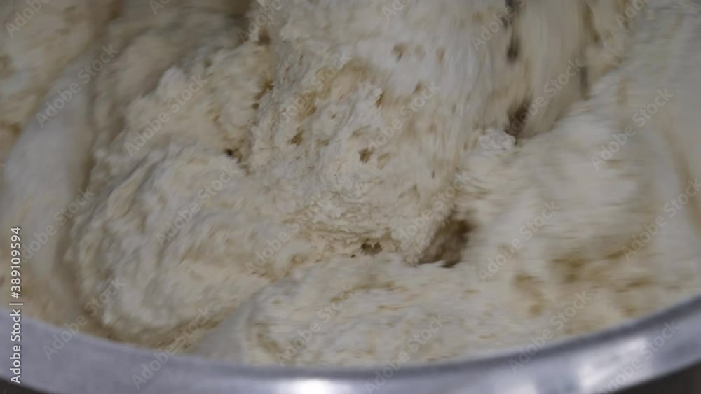 Preparation of dough in production with a professional dough mixer. Industrial mixer for kneading dough Preparation of dough in production with a professional dough mixer. Industrial mixer for kneading dough