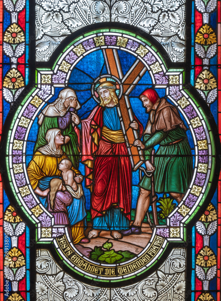 VIENNA, AUSTIRA - OCTOBER 22, 2020: The Jeus meets the women of Jerusalem on the stained glass in church Pfarrkirche Kaisermühlen by workroom Tiroler Glasmalerei-Anstalt from end of 19. cent..