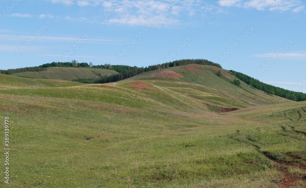 Hills covered with grass and shrubs in the spurs of the Ural mountains. Bashkortostan. Russia.