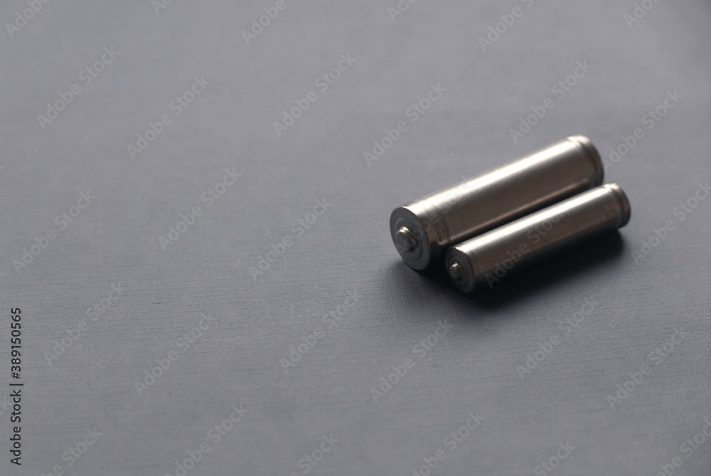 Selective focus of AA and AAA battery on grey background with copy space. Selective focus of AA and AAA battery on grey background with copy space.