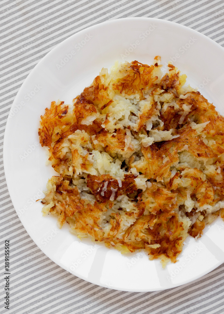 Homemade Fried Hashbrowns on a white plate, top view. Flat lay, overhead, from above. Homemade Fried Hashbrowns on a white plate, top view. Flat lay, overhead, from above.