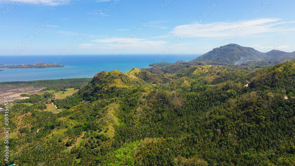 The mountains and hills with tropical forest with blue sea. Tropical landscape, Mindanao, Philippines.