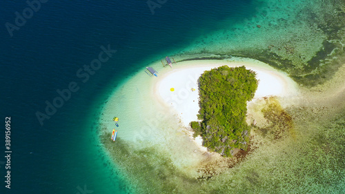 Aerial view of Tropical island with sand beach, palm trees by atoll with coral reef. Britania Islands, Surigao del Sur, Philippines.