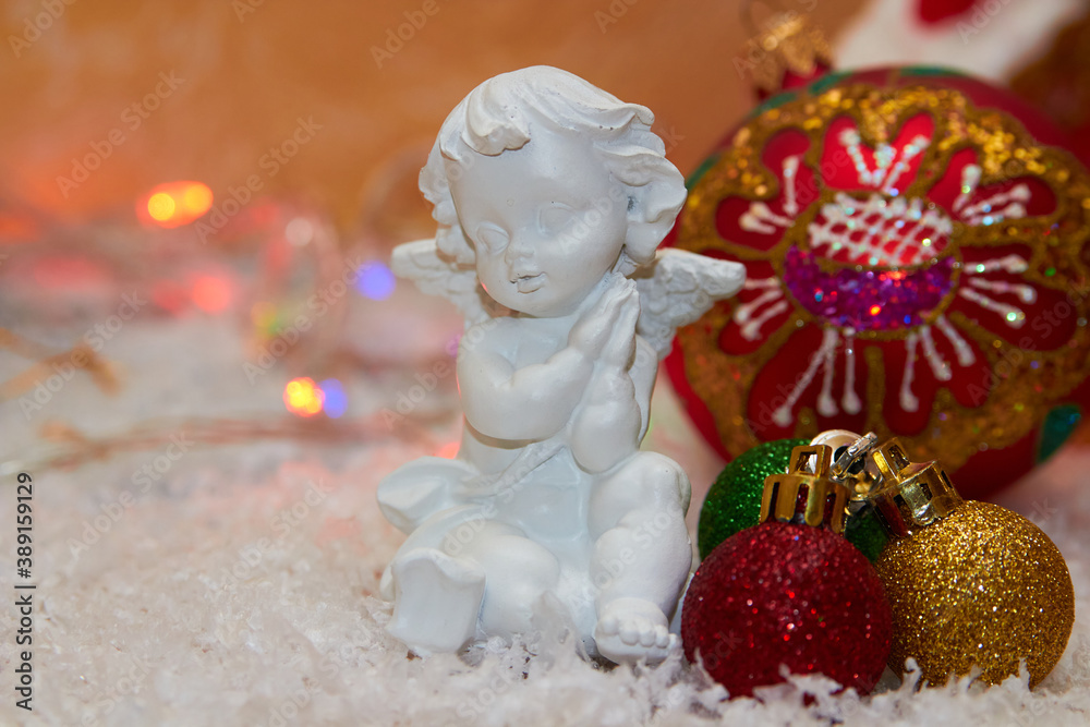 Christmas angel with balls,white little angel decorated for Christmas with snow and balls