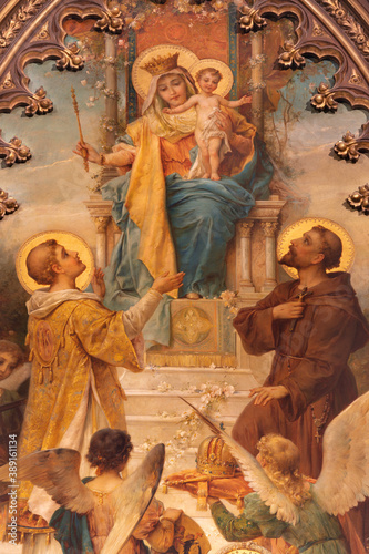 VIENNA, AUSTIRA - OCTOBER 22, 2020: The painting of Madonna wiht the S. Laurence and St. Francis of Assisi in church Laurentiuskirche by Hans Zacka from end of 19. cent..